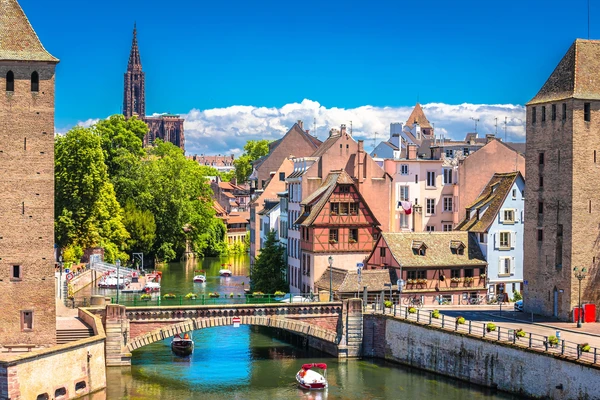 Photographie professionnelle en haute résolution de la cathédrale Notre-Dame de Strasbourg avec ses détails architecturaux distinctifs, prise de jour avec une lumière naturelle, montrant l'élégance et la présence de ce monument emblématique de la ville. L'image doit transmettre la sérénité et la confiance associées à un ancrage territorial solide et établi.